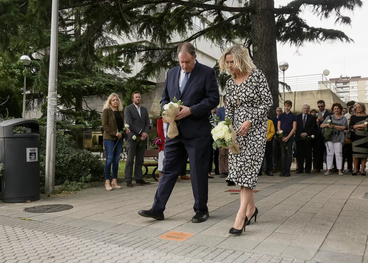 Dovalen seme alabak, aitari loreak eskaintzen. EFE.