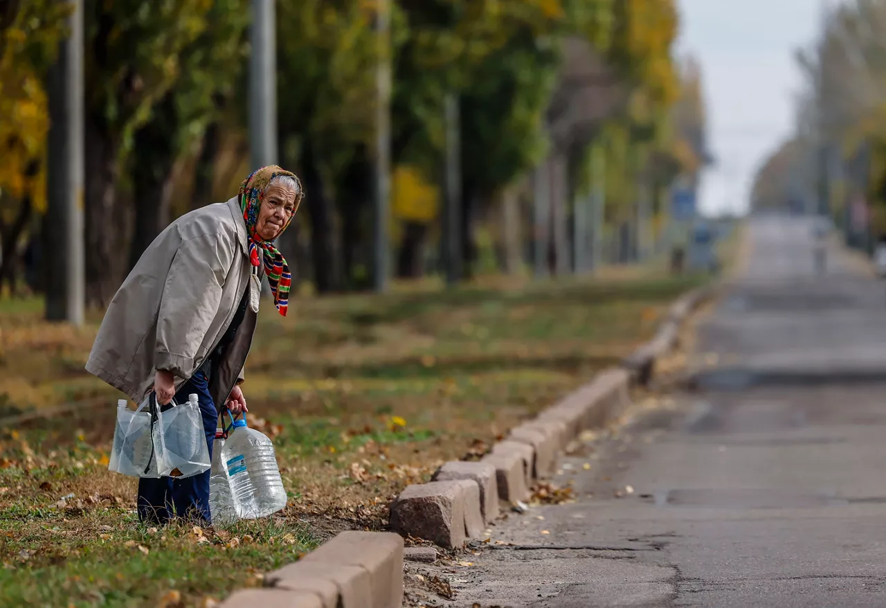Adineko emakume batek edateko ura darama Mykolaiven, Ukrainian. Argazkia: EFE