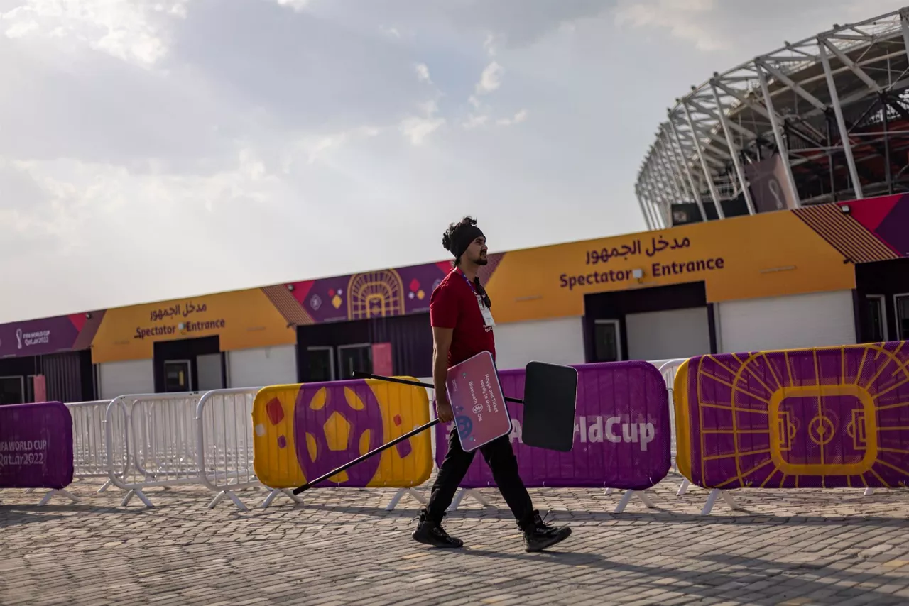 Un trabajador delante de un estadio. Foto: EFE
