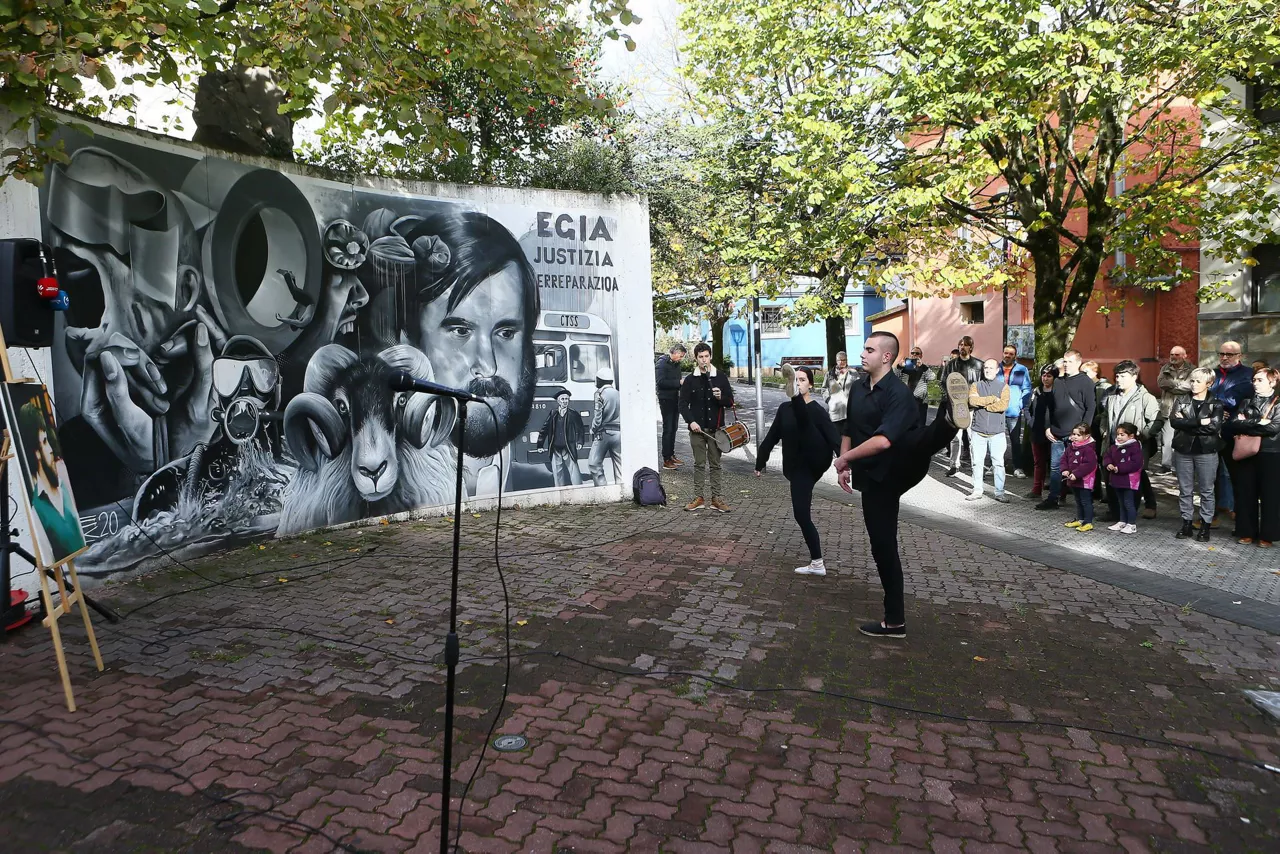 Dantzaris ante el mural de Mikel Zabalza. Foto: EFE