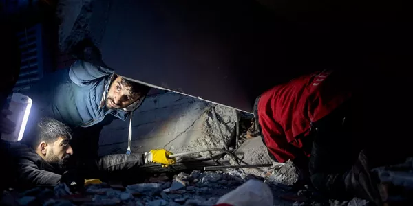 Varias personas tratan de ayudar en la oscuridad y bajo los escombros en Diyabakir (Turquía). Foto: EFE