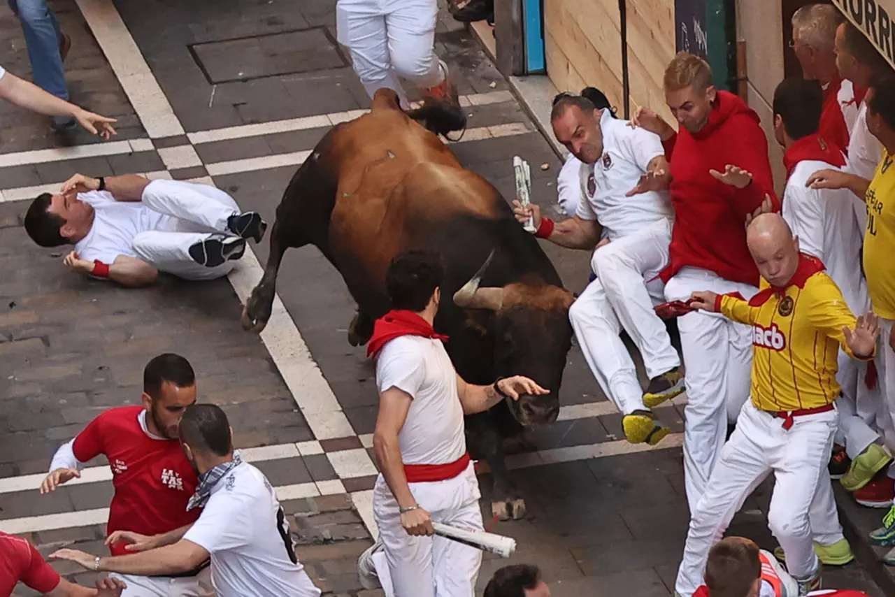 Mozos corren junto a toros de la ganadería Fuente Ymbro. Foto: EFE