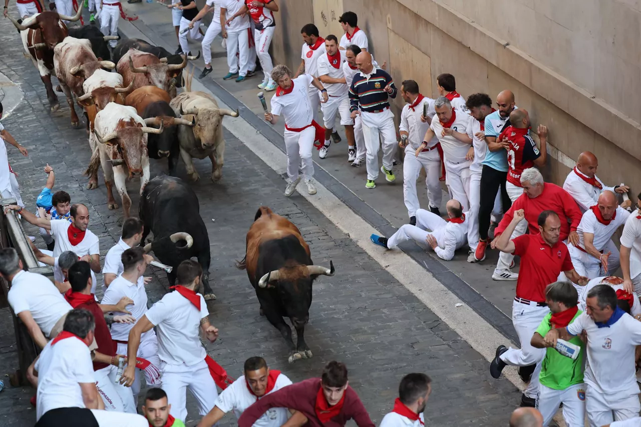 Mozos corren junto a toros de la ganadería Fuente Ymbro. Foto: EFE