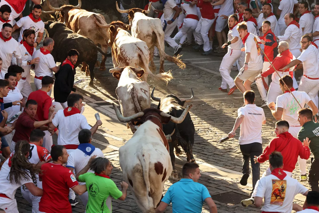 Mozos corren junto a toros de la ganadería Fuente Ymbro. Foto: EFE