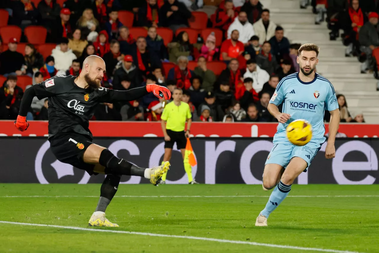 El portero serbio del Mallorca Predrag Rajkovic (i) despeja el balón ante la presión de Jon Moncayola (d), centrocampista del Osasuna