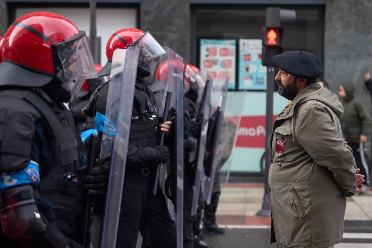 Un hombre en frente de una fila de ertzainas. Foto: EFE