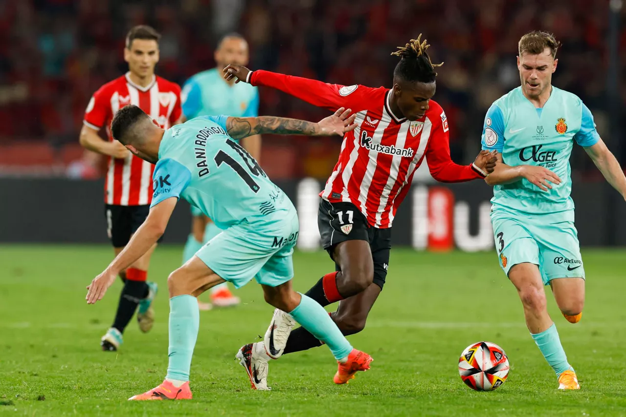 Del Athletic Club Nico Williams intenta llevarse el balón ante los jugadores del Mallorca, Dani Rodríguez  y Toni Lato en la final de Copa