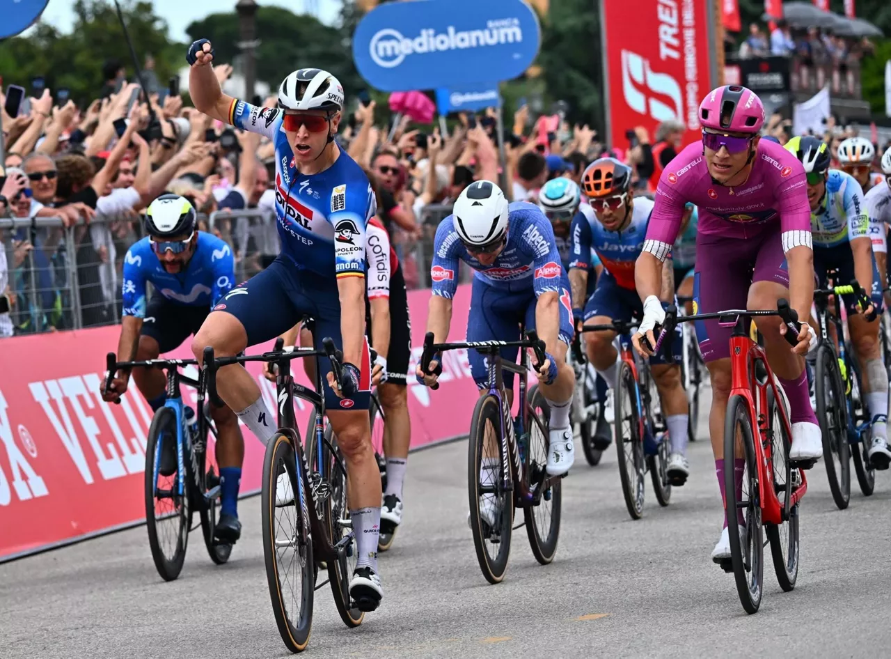 Tim Merlier celebra su victoria, con Jonathan Milan a su izquierda. Foto: EFE.