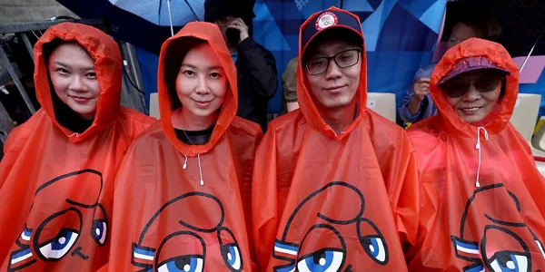 Espectadores se protegen de la lluvia. EFE. 
