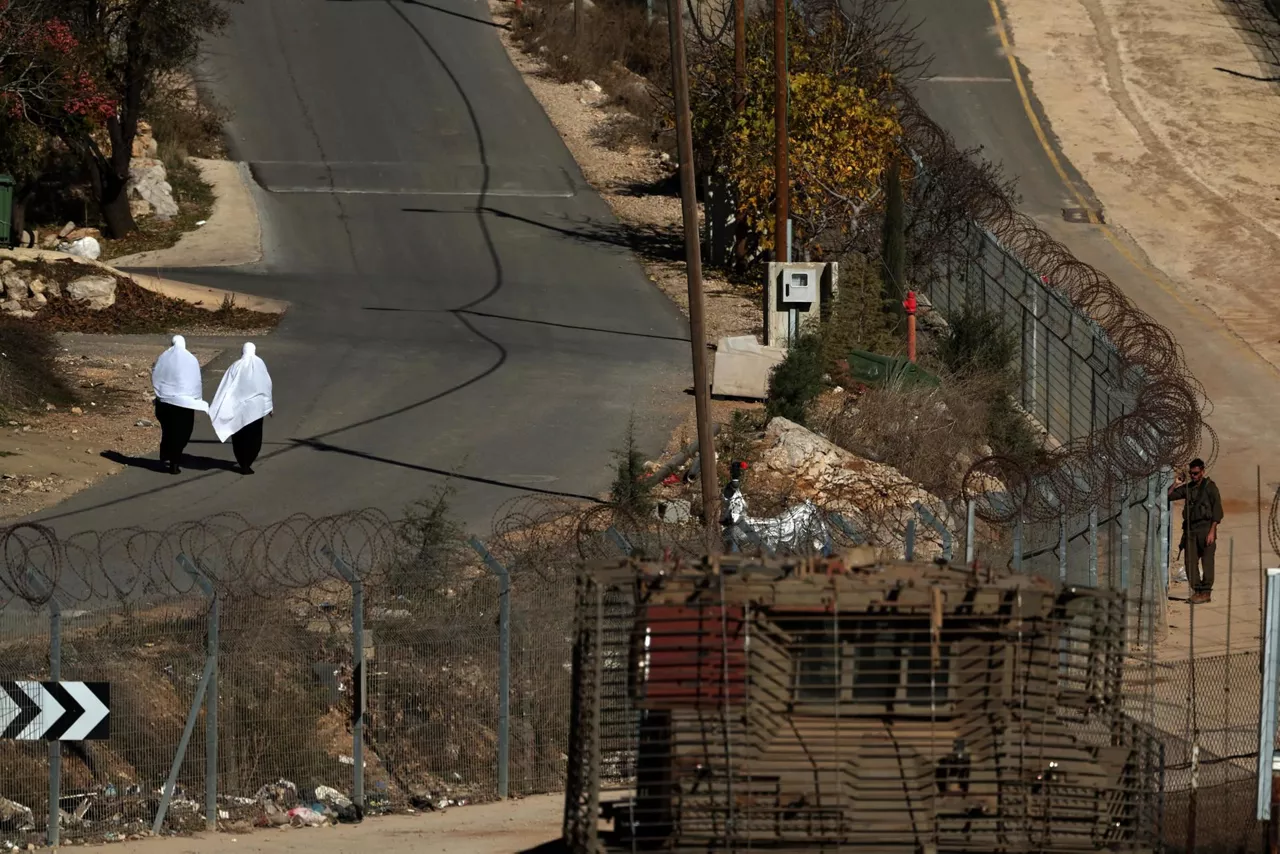 mujeres  drusas pasan junto soldados israelies altos del golan