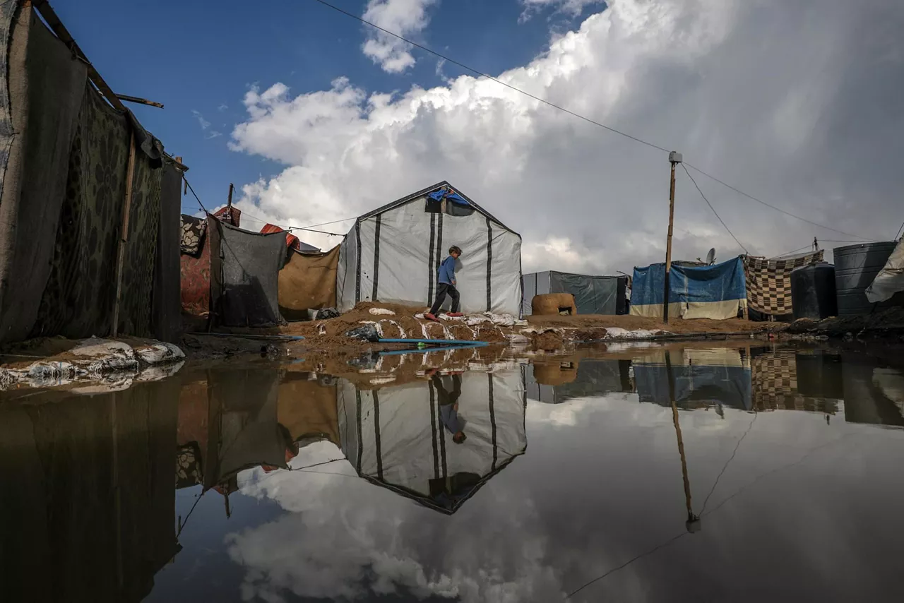 Un niño desplazado camina por un campamento en Deir Al Balah, en la Franja de Gaza. Foto: EFE