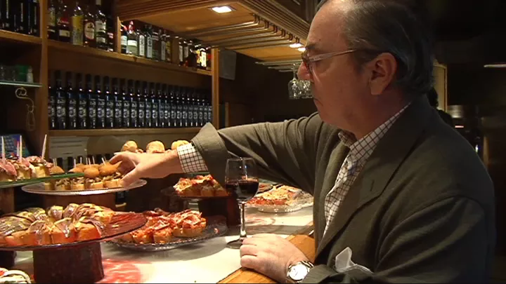 Gizon bat pintxo bat aukeratzen ari da, taberna batean. Argazkia: EITB