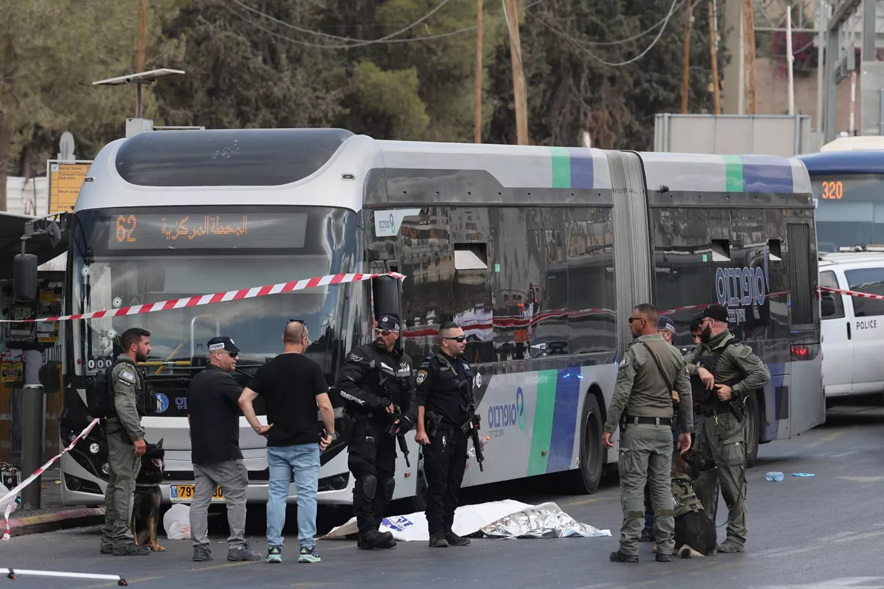 Jerusalem (-), 08/09/2025.- Israeli police officers gather near a body next to a bus as they work at the scene of a shooting incident in Jerusalem, 08 September 2025. At least five people were killed and several others injured by gunfire after a shooting incident at Ramot Junction in Jerusalem, according to Magen David Adom (MDA), Israel's national emergency services. (Jerusalén) EFE/EPA/ABIR SULTAN
