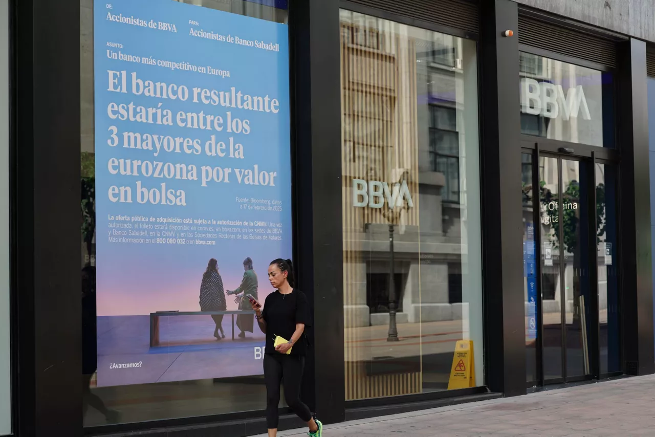 GRAFCAV9209. BILBAO, 24/06/2025.-Un cartel en una sucursal del BBVA, en Bilbao este martes aludiendo a la fusión entre BBVA y Sabadell. La Comisión Europea recordó este martes que cualquier condición impuesta por un Gobierno para aprobar una transacción debería ser "excepcional, proporcionada y justificada por razones de interés público válidas", aunque rehusó pronunciarse en concreto sobre la decisión del Ejecutivo español respecto a la opa del BBVA por el Sabadell. EFE/Luis Tejido
