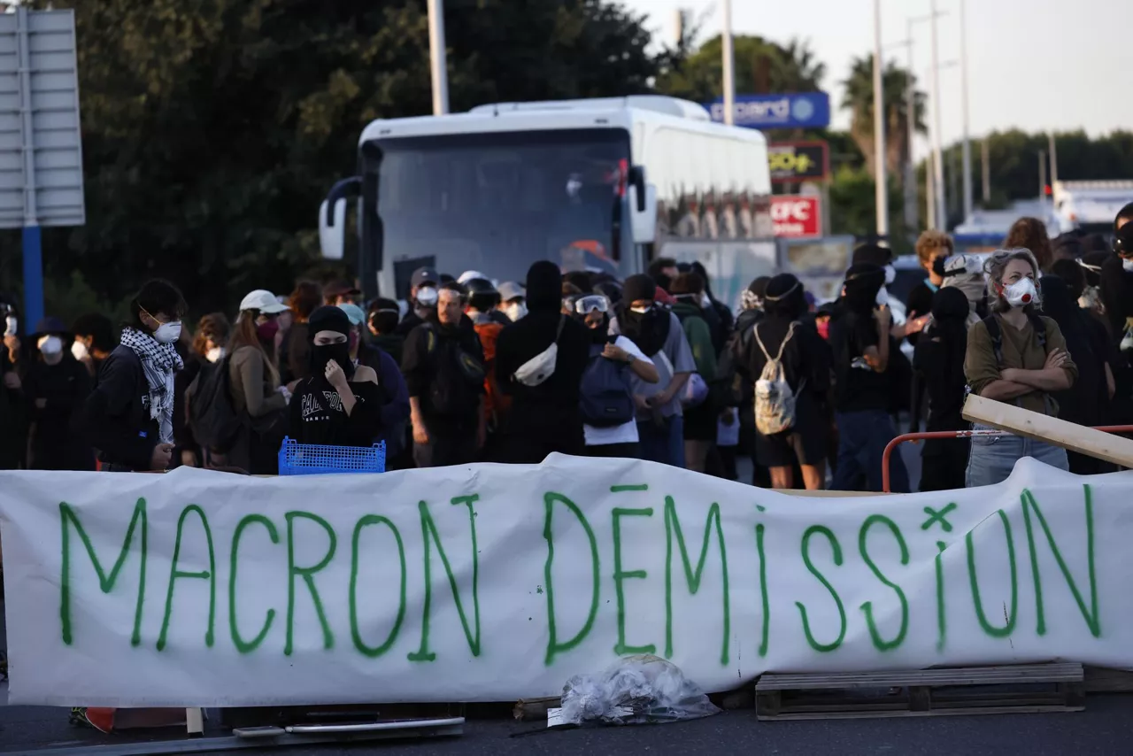 MONTPELLIER (France), 10/09/2025.- Protesters hold a banner calling for French President Macron to resign while blocking a street during a call for action by 'Bloquons tout' (Block everything) collective in Montpellier, France, 10 September 2025. In a protest against the outgoing government's austerity budget, an online collective called 'Bloquons Tout' has called for everyone to block the entire country on 10 September with symbolic actions. (Protestas, Francia) EFE/EPA/GUILLAUME HORCAJUELO
