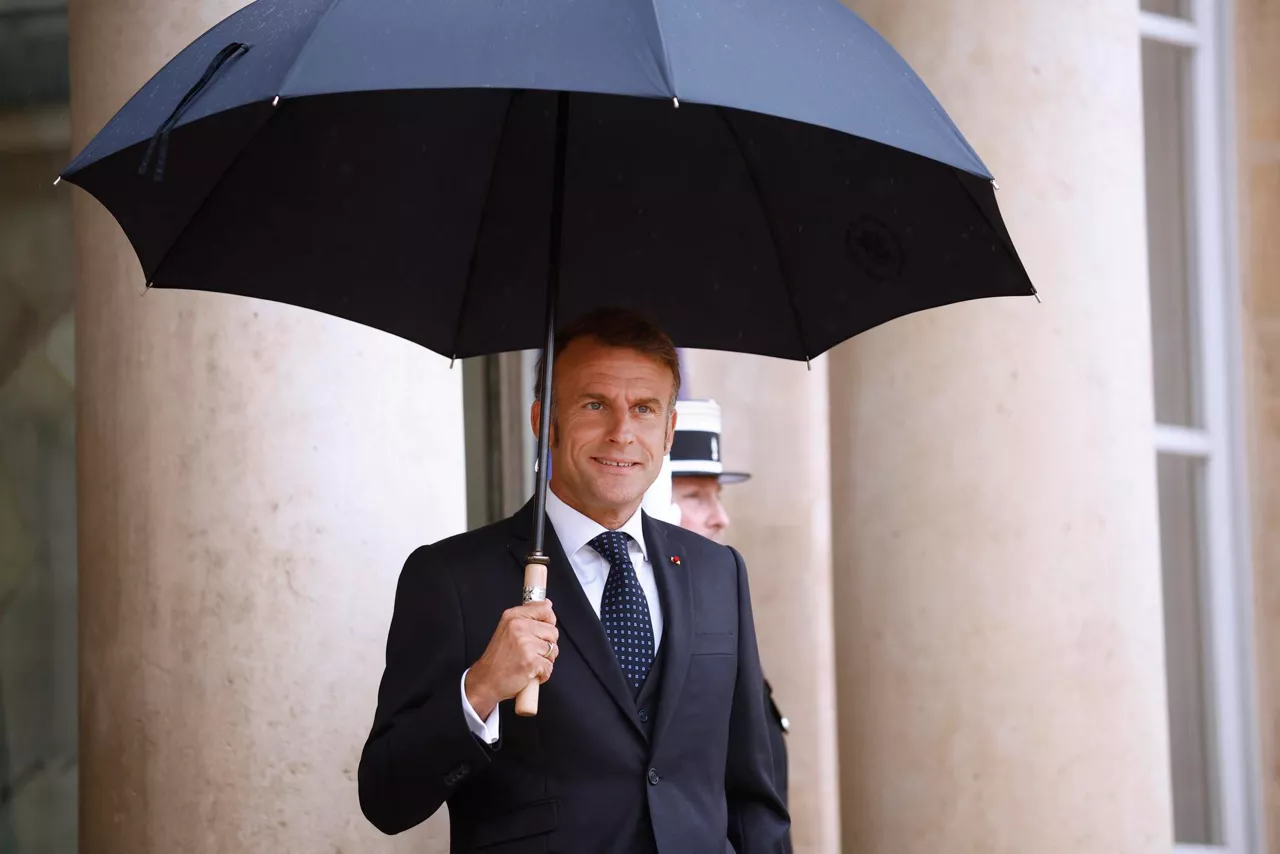 Paris (France), 24/07/2025.- French President Emmanuel Macron holds an umbrella as he awaits the Lebanese Prime Minister Nawaf Salam (not pictured) upon his arrival at the Elysee Palace in Paris, France, 24 July 2025. This marks the first official visit of the Lebanese prime minister to France, with the purpose to reaffirm the diplomatic relationship between the two countries. (Francia, Líbano) EFE/EPA/YOAN VALAT
