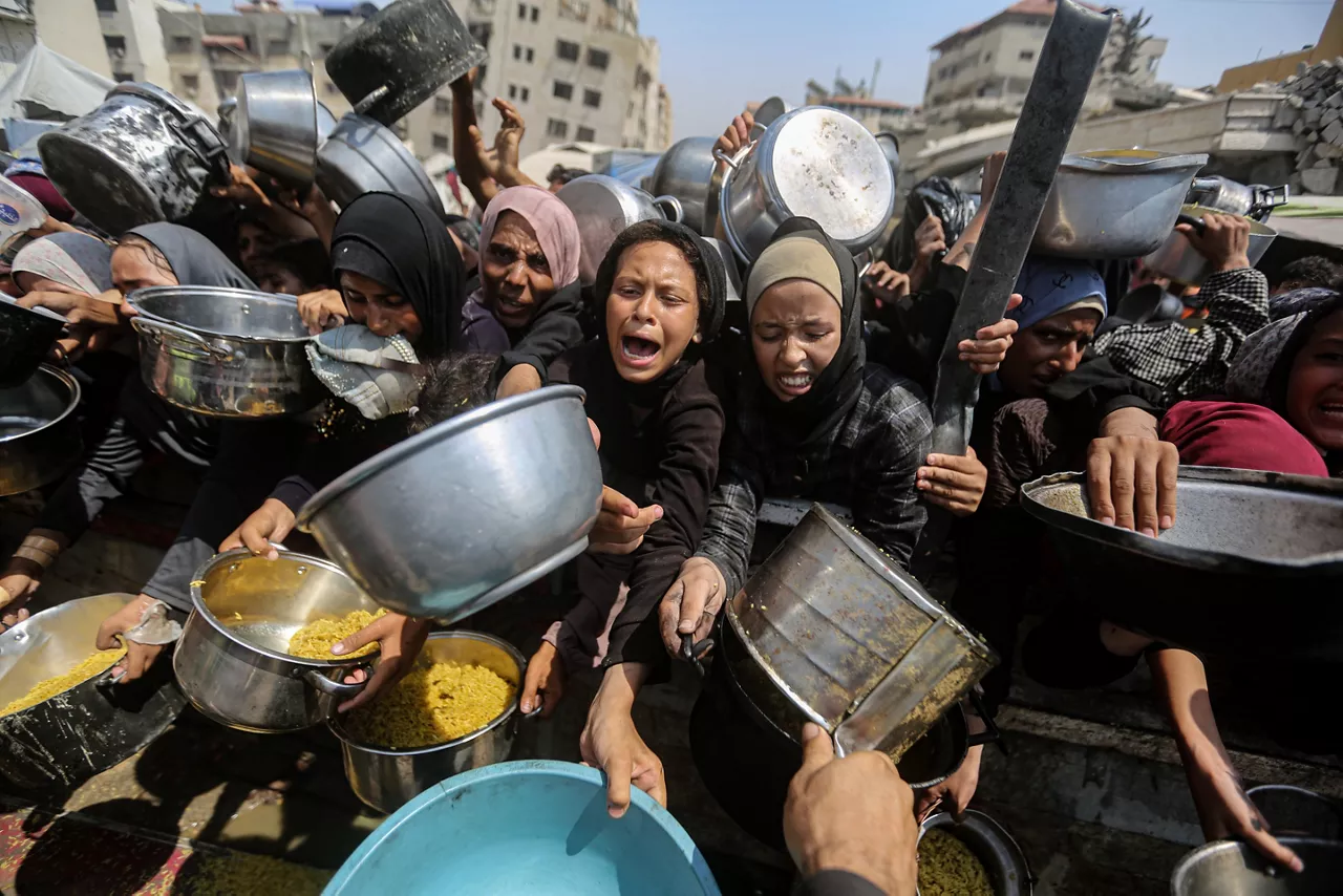 Desplazados de Gaza esperando para recibir alimentos por la hambruna