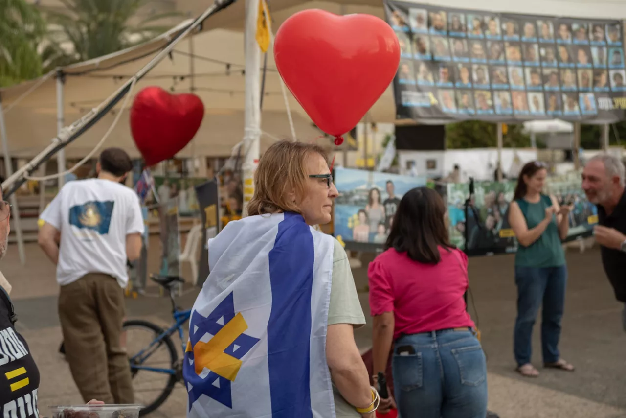 09 October 2025, Israel, Tel Aviv: A woman wearing the Israeli flag holds a heart shaped balloon as people gather at hostage square in Tel Aviv to celebrate the ceasefire deal. After 2 years of war, Israel and Hamas have agreed on the first phase of the peace plan suggested by US President Donald Trump, where all hostages held in Gaza are to be released, and Israeli forces will withdraw to an agreed upon line. Photo: Ilia Yefimovich/dpa



09/10/2025 ONLY FOR USE IN SPAIN