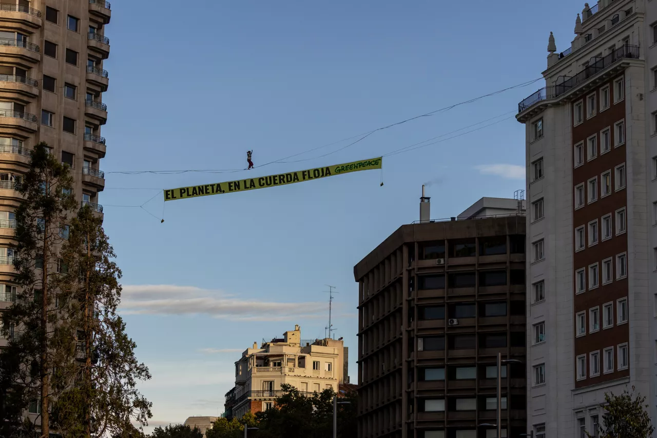 Una activista de Greenpeace camina sobre el cielo de Madrid en el inicio de la COP30

