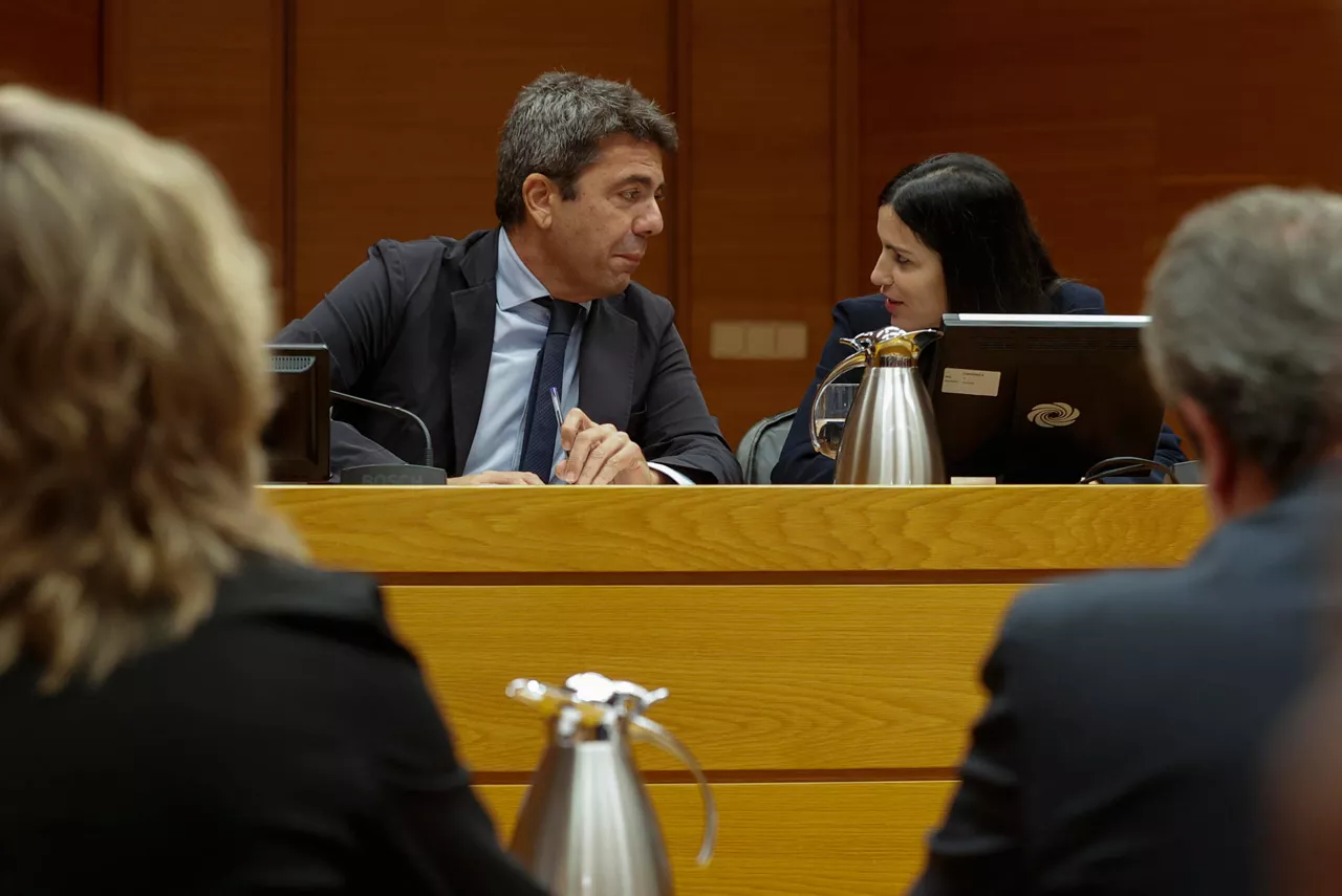 GRAFCVA309. VALENCIA, 11/11/2025.- El president de la Generalitat en funciones, Carlos Mazón, conversa con la presidenta de la comisión, Míriam Turiel (Vox), durante su comparecencia en la comisión de investigación de Les Corts Valencianes sobre la dana, su primera aparición pública tras su dimisión el pasado 3 de noviembre. EFE/Manuel Bruque
