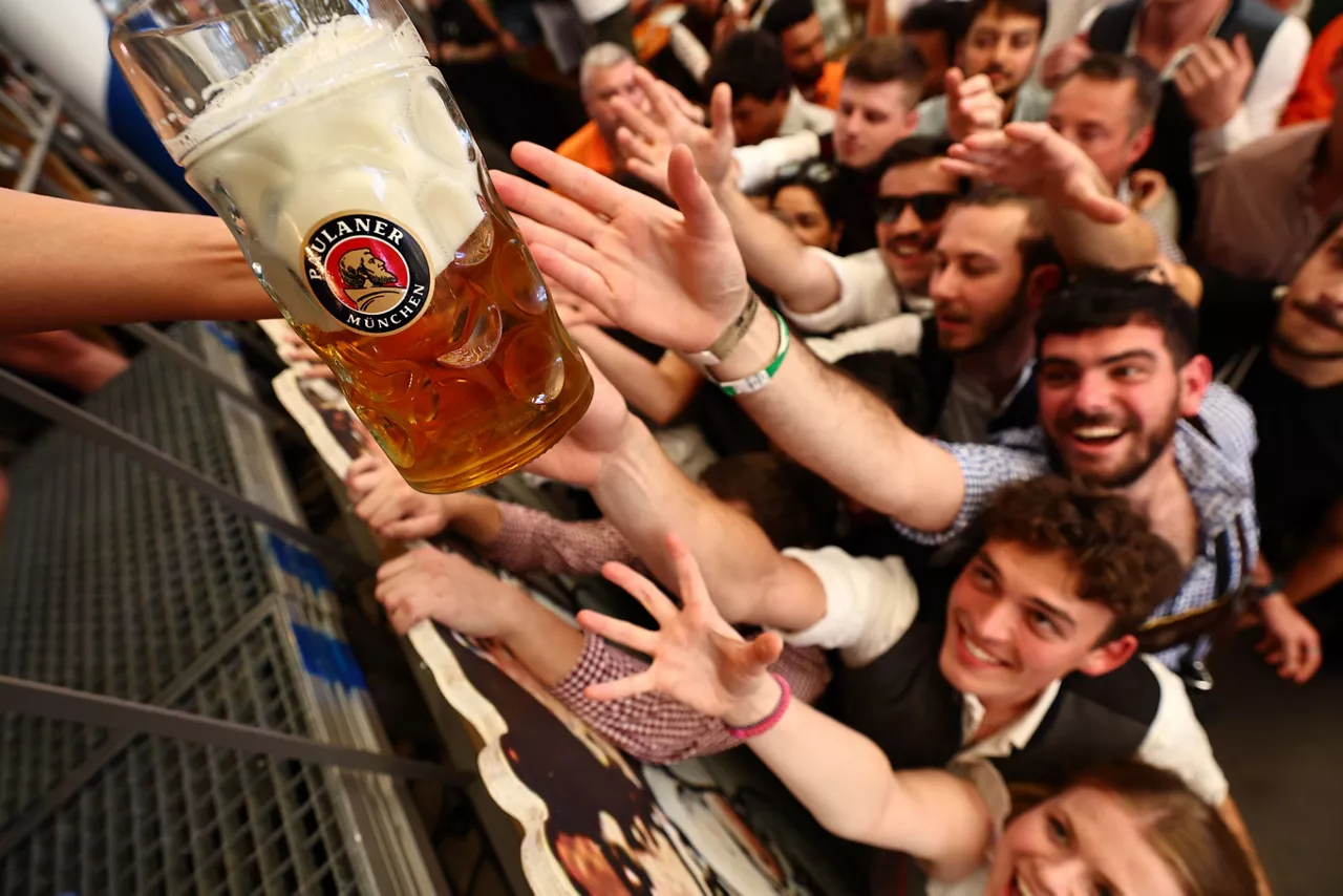 Visitors gather for the handing out of the first beer at the Paulaner brewery tent during the opening of the 190th edition of the traditional Oktoberfest beer and amusement festival in the Bavarian capital Munich, Germany, 20 September 2025. According to its organizers, the Oktoberfest has grown into the world's largest folk festival, drawing around six million visitors annually. The festival's 190th edition will run from 20 September to 05 October 2025 on the Theresienwiese.