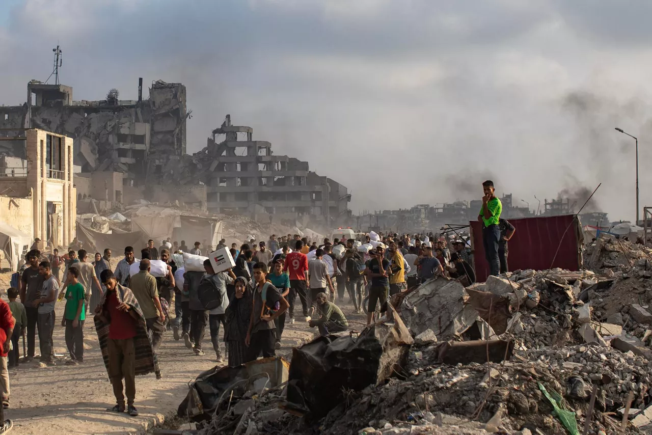 Al-Rashid Street (-), 22/06/2025.- Displaced Palestinians carry relief packages along Rashid Street, west of Jabalia, 22 June 2025, after humanitarian aid trucks entered the northern Gaza Strip through the Israeli-controlled Zikim crossing, northwest of Gaza City. More than 55,700 Palestinians have been killed in the Gaza Strip, according to the Palestinian Ministry of Health, since Israel launched a military campaign in the strip in response to a cross-border attack led by the Palestinian militant group Hamas on 07 October 2023. EFE/EPA/HAITHAM IMAD
