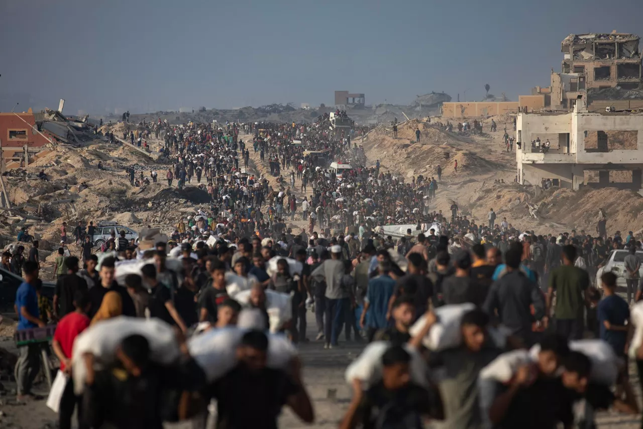 Al-Rashid Street (-), 22/06/2025.- Displaced Palestinians carry relief packages along Rashid Street, west of Jabalia, 22 June 2025, after humanitarian aid trucks entered the northern Gaza Strip through the Israeli-controlled Zikim crossing, northwest of Gaza City. More than 55,700 Palestinians have been killed in the Gaza Strip, according to the Palestinian Ministry of Health, since Israel launched a military campaign in the strip in response to a cross-border attack led by the Palestinian militant group Hamas on 07 October 2023. EFE/EPA/HAITHAM IMAD
