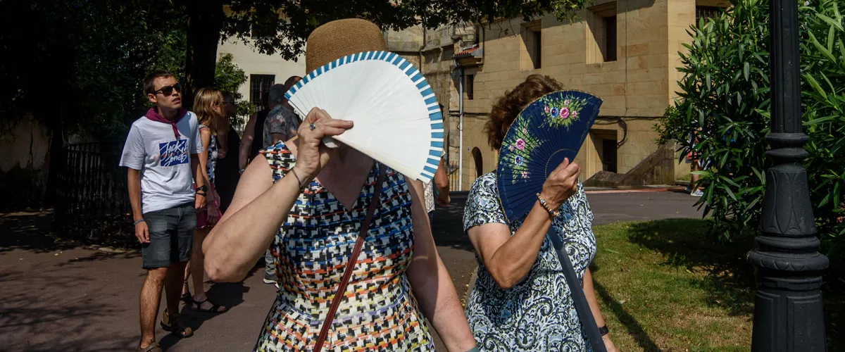 BILBAO, 15/08/2025.- Dos mujeres se protegen del sol con sus abanicos, este viernes en Bilbao, donde han decretado alerta naranja por altas temperaturas. Numerosas localidades de Euskadi han registrado una nueva noche tropical, con mínimas que no han bajado de los 20 grados, que augura una jornada que desde la Agencia Vasca de Meteorología-Euskalmet prevén que pueda ser la más calurosa del verano en la comunidad autónoma. EFE/ Javier Zorrilla
