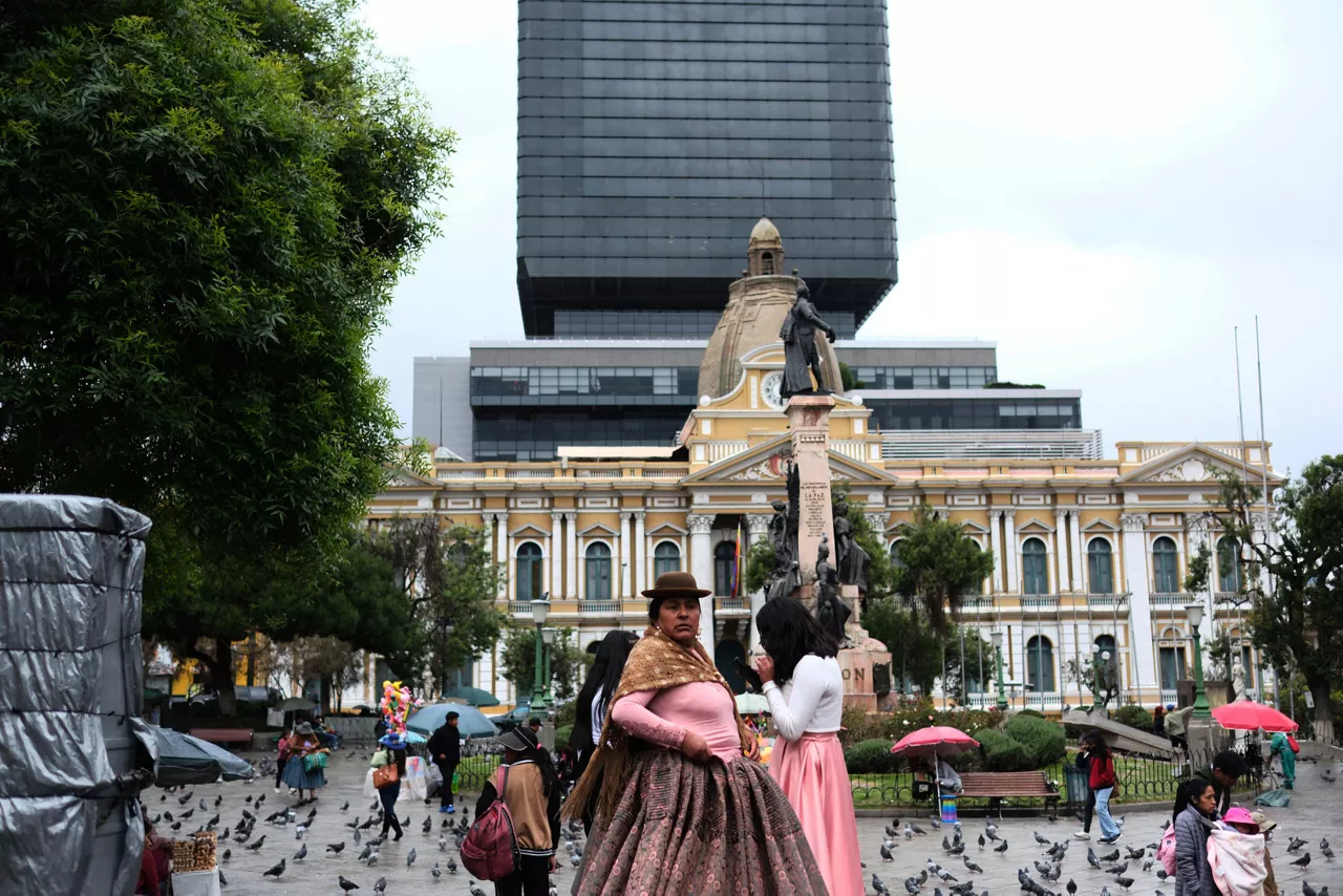 AME9281. LA PAZ (BOLIVIA), 18/10/2025.- Una mujer aimara camina este sábado en la plaza Murillo, lugar donde se encuentra la sede Política en La Paz (Bolivia). Los bolivianos volverán a las urnas este domingo para elegir por primera vez en su historia a su presidente y vicepresidente en una segunda vuelta que disputarán el senador centrista Rodrigo Paz y el exmandatario conservador Jorge Quiroga y que también supondrá un nuevo ciclo político y económico tras 20 años de la izquierda en el poder. EFE/Luis Gandarillas
