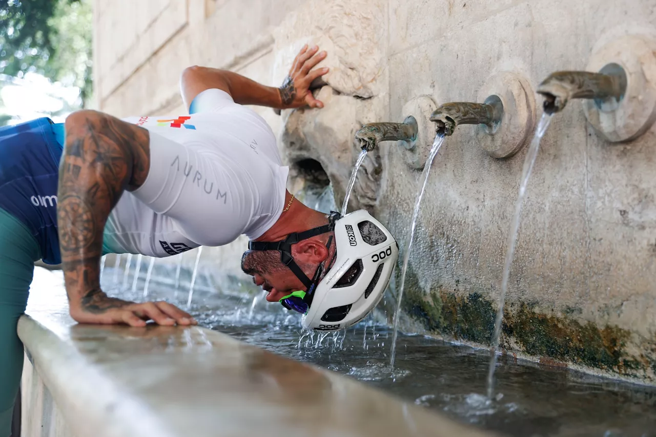 GRAFCVA8910. XÀTIVA (VALENCIA), 11/08/2025.- La Agencia Estatal de Meteorología (Aemet) ha anunciado que este lunes y el martes serán, con toda probabilidad, los días más cálidos del verano en la Comunitat Valenciana, y ha activado el aviso naranja por temperaturas de 40 grados en el interior sur de Valencia y de 39 grados en el litoral de esta provincia, y el aviso amarillo por lluvias de 20 l/m2 en una hora en el interior sur de Castellón y el interior norte de Valencia y tormentas en las mismas zonas con probable granizo y rachas muy fuertes de viento. En la imagen un ciclista se refresca en una fuente en la localidad valenciana de Xàtiva. EFE/Manuel Bruque
