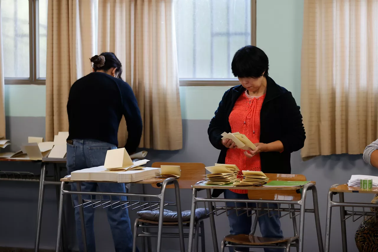 Personas alistan un centro de votación durante el inicio de la jornada electoral este domingo, en Paine (Chile). Un total de 3.498 centros de votación abrieron sus puertas para dar comienzo a las elecciones presidenciales y legislativas en Chile, en las que se escogerá al sucesor del progresista Gabriel Boric y se renovará el Parlamento.