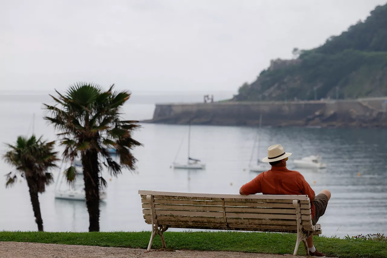 SAN SEBASTIÁN (ESPAÑA), 23/06/2025.- Un turista se observa la bahía de la Concha de San Sebastián. El tiempo previsto para este lunes en Euskadi es de cielo nuboso a muy nuboso en la vertiente cantábrica, con lloviznas dispersas por la mañana y disminución de la nubosidad por la tarde, y poco nuboso en el interior, aunque de nuevo con nubes de evolución en la segunda mitad del día que podrán provocar chubascos tormentosos al anochecer. EFE/Juan Herrero.
