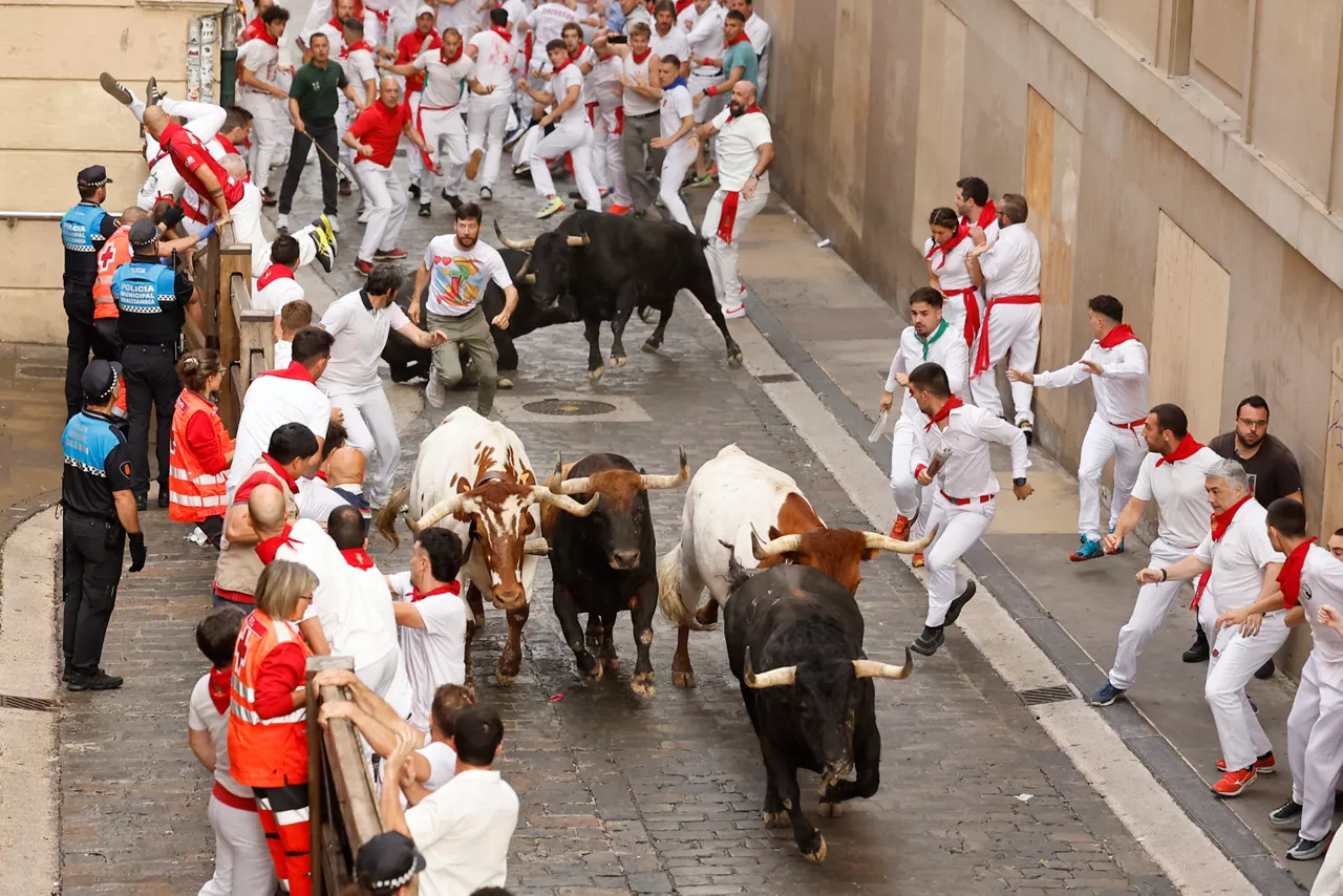 PAMPLONA, 07/07/2025.- Los mozos son perseguidos por toros de la ganadería gaditana de Fuente Ymbro durante el primer encierro de los Sanfermines 2025, este lunes en Pamplona. EFE/ Villar López
