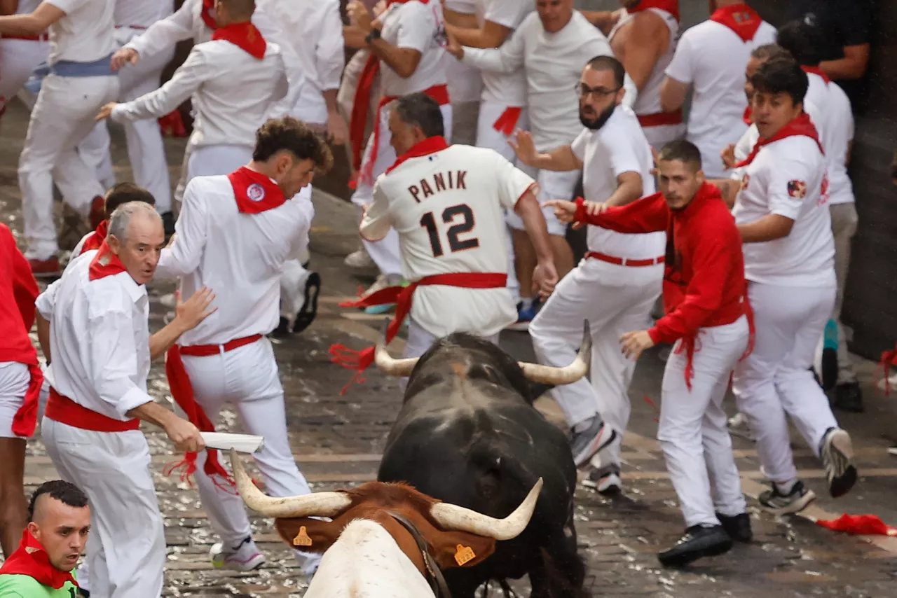 PAMPLONA, 07/07/2025.- Los mozos son perseguidos por toros de la ganadería gaditana de Fuente Ymbro durante el primer encierro de los Sanfermines 2025, este lunes en Pamplona. EFE/ Villar Lopez
