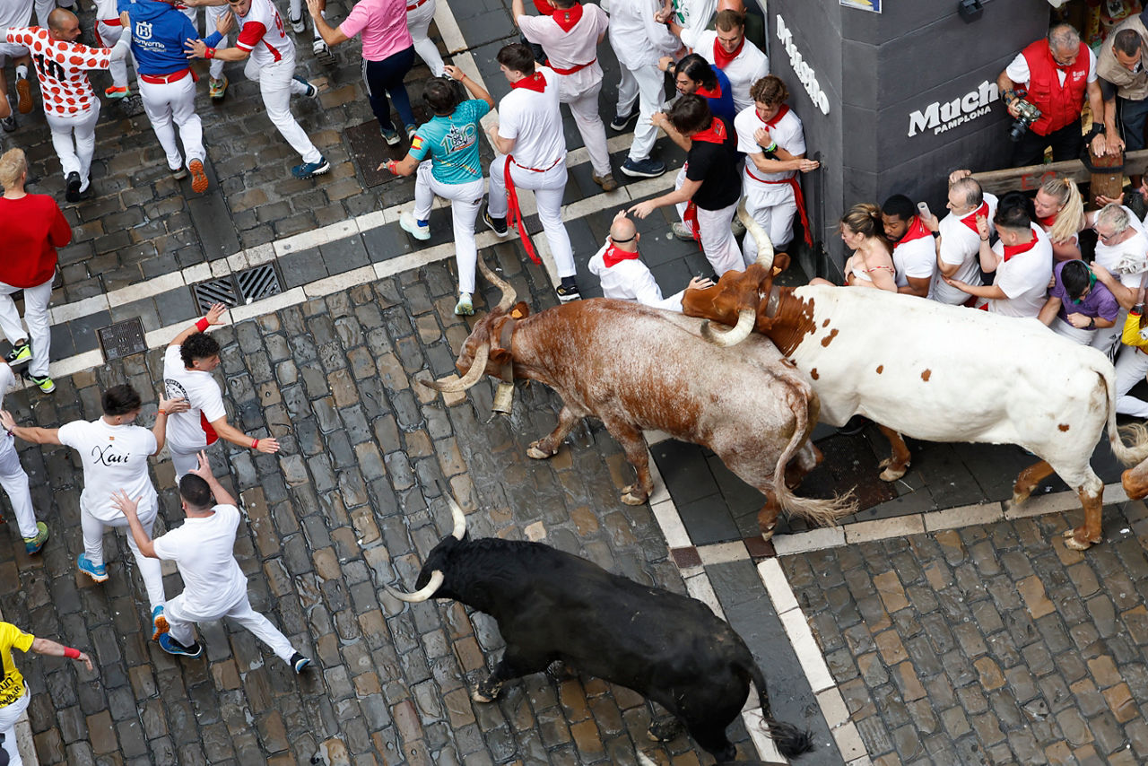 PAMPLONA, 07/07/2025.- Los mozos son perseguidos por toros de la ganadería gaditana de Fuente Ymbro durante el primer encierro de los Sanfermines 2025, este lunes en Pamplona. EFE/Jesús Diges
