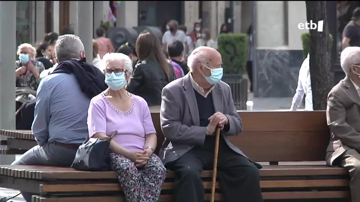 Bikote bate maskarillarekin kalean. EITB Mediaren bideo batetik ateratako irudia.