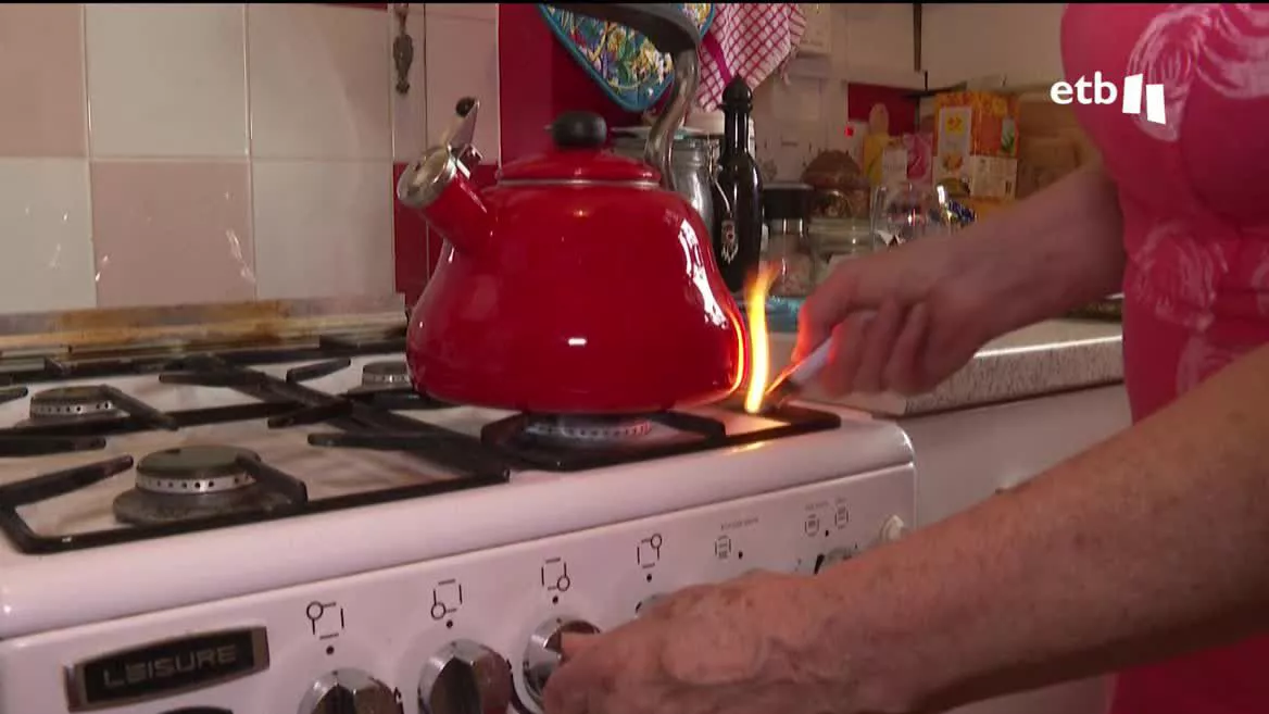 Una mujer encendiendo la cocina.