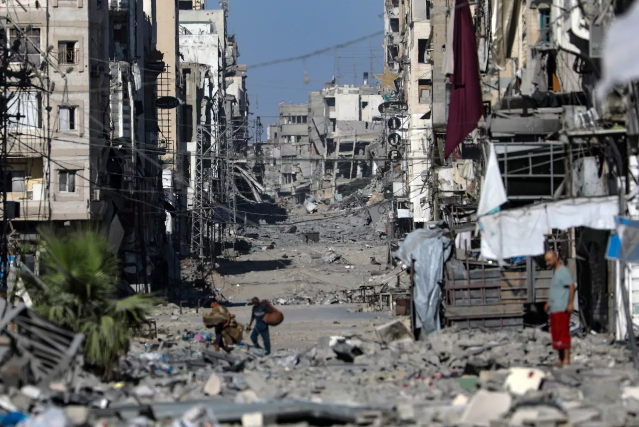GAZA CITY (---), 07/10/2025.- Palestinians move on the damaged Al-Nassr street during an Israeli military operation in Gaza City, Gaza Strip, 07 October 2025. According to the UN around 90 percent of the population or 1.9 million people in Gaza have been displaced since the start of the conflict. More than 67,000 Palestinians have been killed in the Gaza Strip since October 2023, according to the Palestinian Ministry of Health, and about 1,200 Israelis have been killed since the launch of an Israeli military campaign in response to a cross-border attack by Hamas on 07 October 2023. EFE/EPA/MOHAMMED SABER
