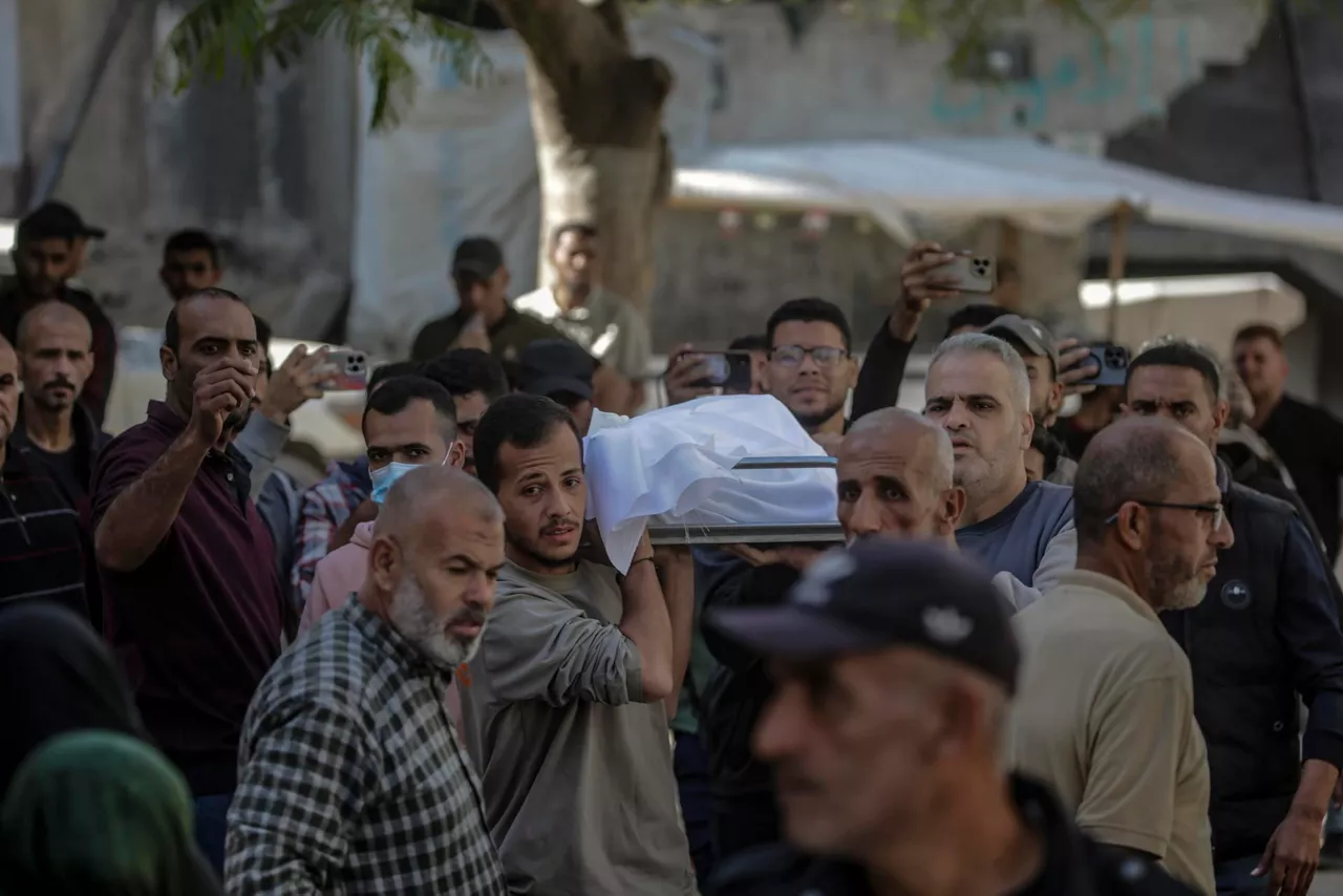 GAZA CITY (---), 23/11/2025.- Palestinians carry the body of a person killed in Israeli air strikes, at Al-Shifa Hospital in Gaza City, 23 November 2025. According to the Palestinian Ministry of Health in Gaza, at least 24 Palestinians were killed November 22 in Israeli air strikes on the Gaza Strip. EFE/EPA/MOHAMMED SABER
