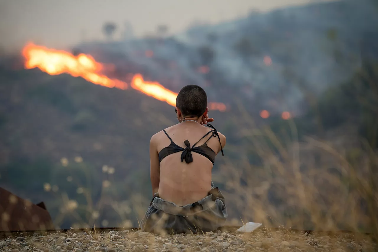 FOTODELDÍA EPA9432. QUÍOS (GRECIA), 12/08/2025.- Una persona observa un incendio forestal en una zona montañosa entre Potamia y Pispilounta este martes, en la isla de Quíos (Grecia). Al menos 25 bomberos, incluyendo un comando forestal, combaten el incendio que se extiende por el norte de la isla, lo que ha activado alertas de emergencia que instan a los residentes a prepararse para las evacuaciones. EFE/EPA/ Kostas Kourgias
