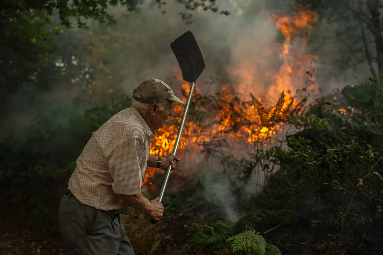 FOTODELDÍA - A Pobra de Trives (Ourense), 13/08/2025.- Un vecino de la aldea de Pareisás lucha contra en fuego en el incendio forestal que permanece activo en A Pobra de Trives (Ourense). EFE/Brais Lorenzo
