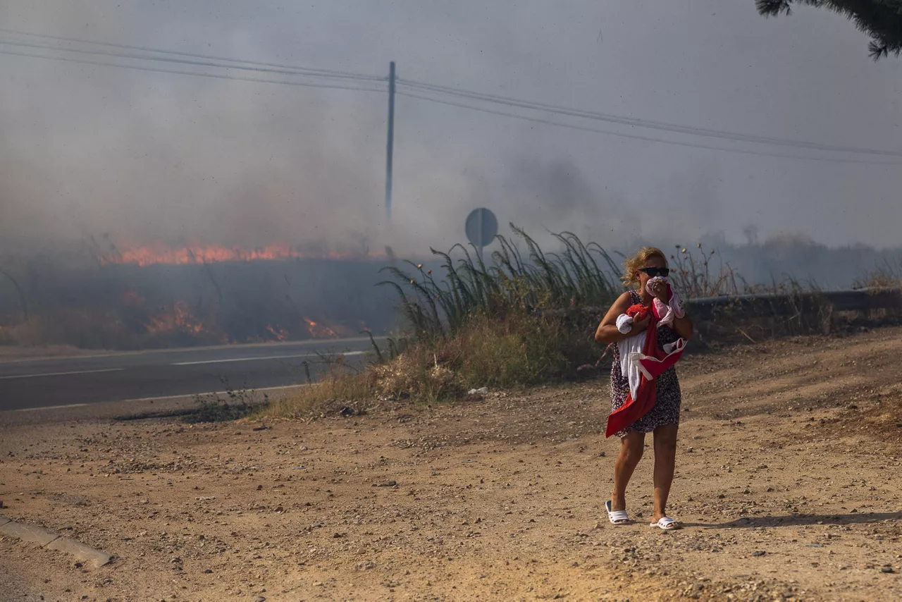 TORRIJOS (TOLEDO), 12/08/2025.- Una mujer junto al incendio que se ha declarado esta tarde entre Torrijos y Novés en la provincia de Toledo, que está afectando a una zona de rastrojos, aunque se ha extendido con rapidez debido al fuerte viento. EFE/Ismael Herrero
