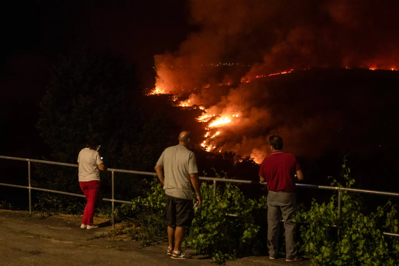 AS CHAS, OÍMBRA (OURENSE), 12/08/2025.- Vista de la aldea de As Chás, Oímbra (Ourense), durante el incendio forestal que permanece activo este martes por la noche. EFE/Brais Lorenzo
