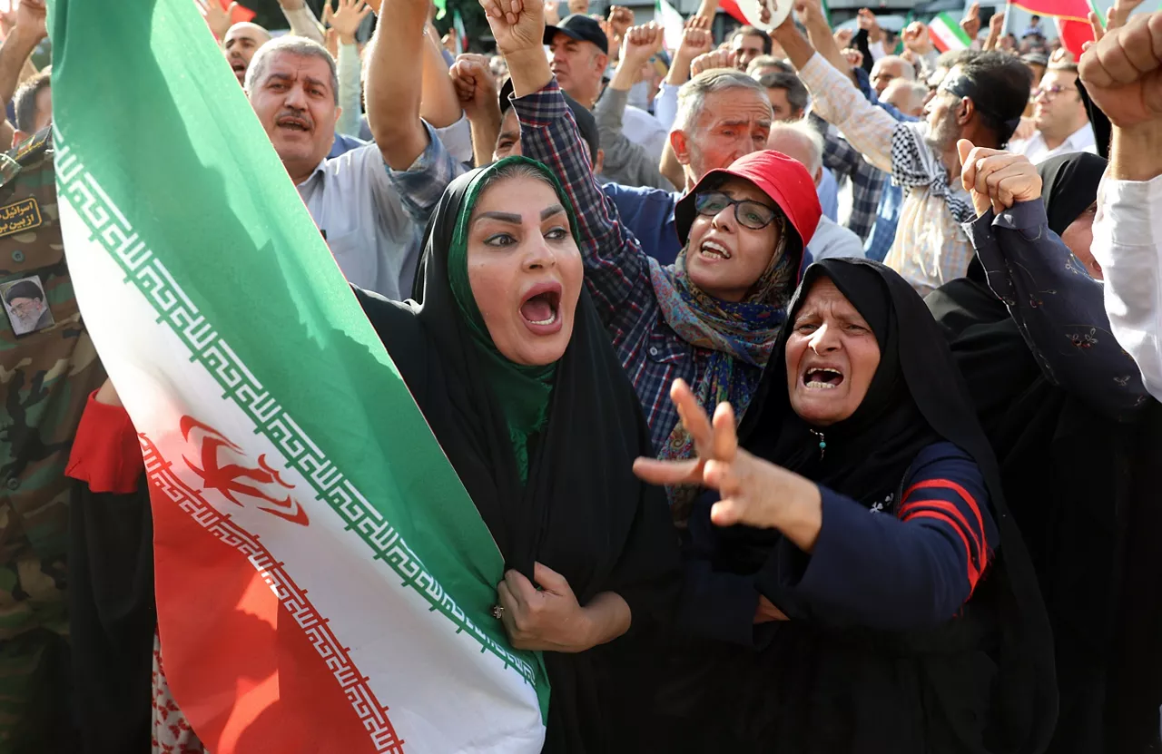 Tehran (Iran (Islamic Republic Of)), 22/06/2025.- An Iranian woman holding a national flag shouts slogans during an anti-US and anti-Israel demonstration in Tehran, Iran, 22 June 2025. The US Department of Defense announced on 22 June, that the US Central Command conducted overnight strikes against three nuclear facilities in Iran. These US strikes come as Israel has been conducting its campaign across Iran since 13 June, targeting nuclear, military, and energy facilities, prompting Iran to launch retaliatory waves of missiles and drones toward Israel. (Teherán) EFE/EPA/ABEDIN TAHERKENAREH
