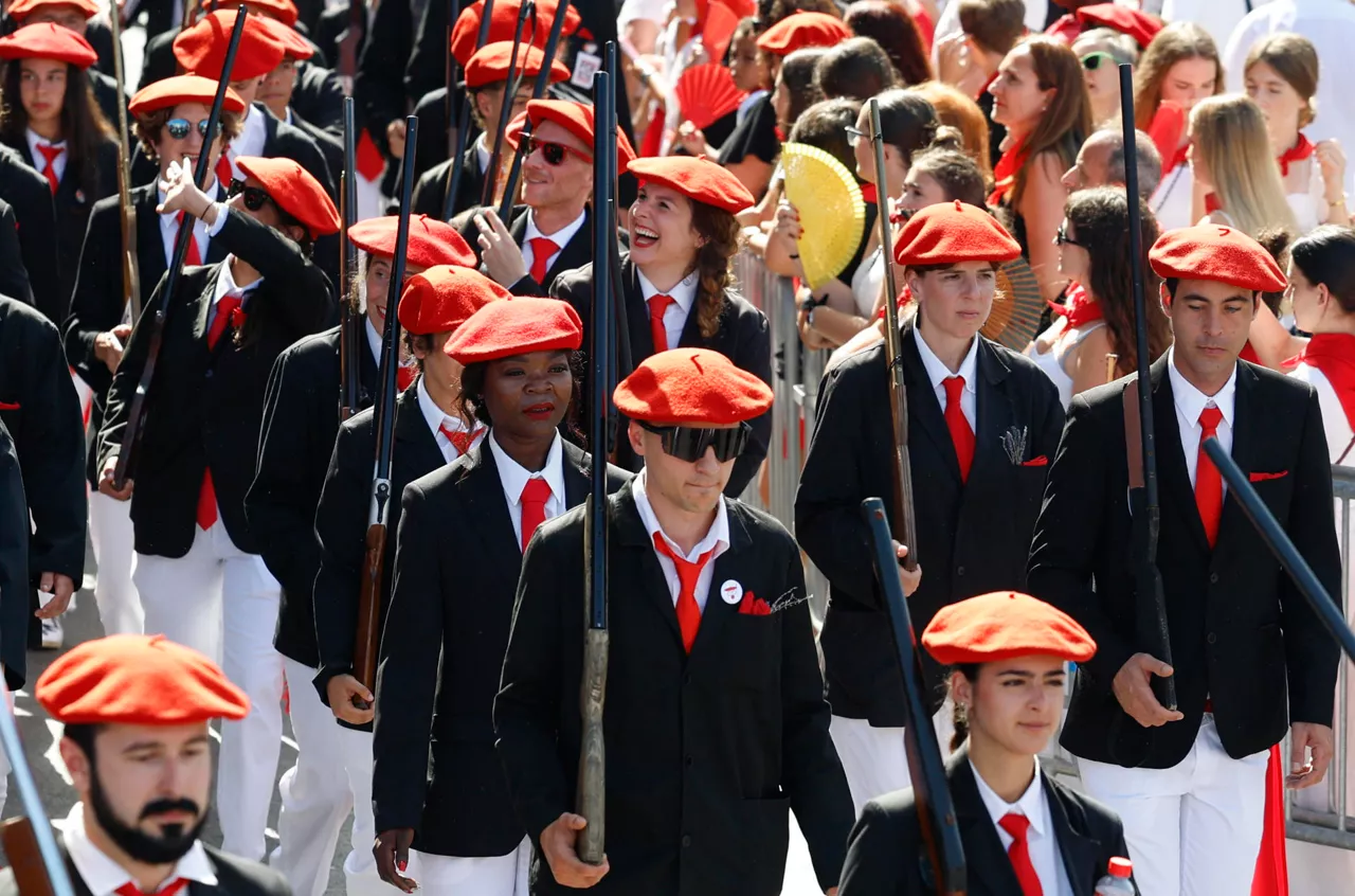 GRAFCAV9431. IRUN (GIPUZKOA) (ESPAÑA), 30/06/2025.-  Participantes en el alarde mixto, en el que las mujeres ejercen como escopeteras, celebran este lunes en Irun su día de San Marcial, en el que las altas temperaturas han sido protagonistas de una jornada en la que la ciudad entera se ha echado a la calle. EFE/Juan Herrero.
