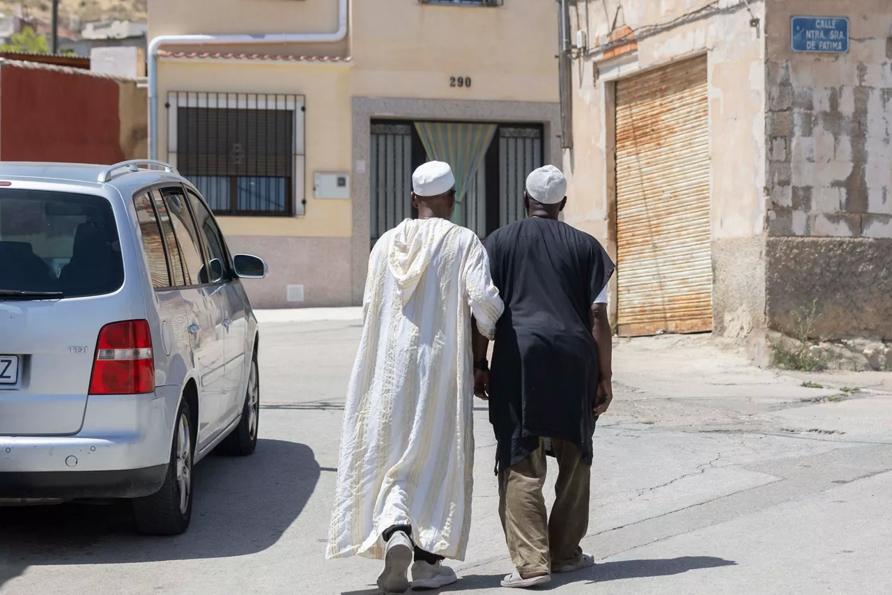 JUMILLA, (MURCIA), 07/08/2025.- Dos hombres de origen marroquí este jueves en el barrio de Nuestra Señora de Fátima de Jumilla. La decisión del Ayuntamiento de Jumilla, un pueblo del sureste español gobernado por la derecha y donde residen miles de inmigrantes, de prohibir actos religiosos en espacios municipales donde se celebraban ceremonias islámicas como el fin del Ramadán, ha desatado indignación e incertidumbre entre la comunidad musulmana semanas después de los incidentes racistas registrados en una localidad próxima.
. EFE/Marcial Guillén
