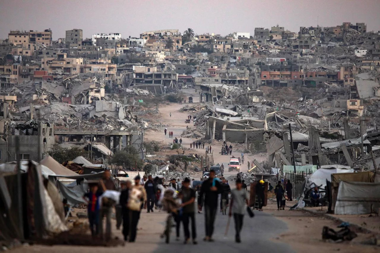 GAZA (---), 25/10/2025.- Palestinians walk among the ruins of their destroyed homes in Khan Younis, southern Gaza Strip, 25 October 2025. EFE/EPA/HAITHAM IMAD
