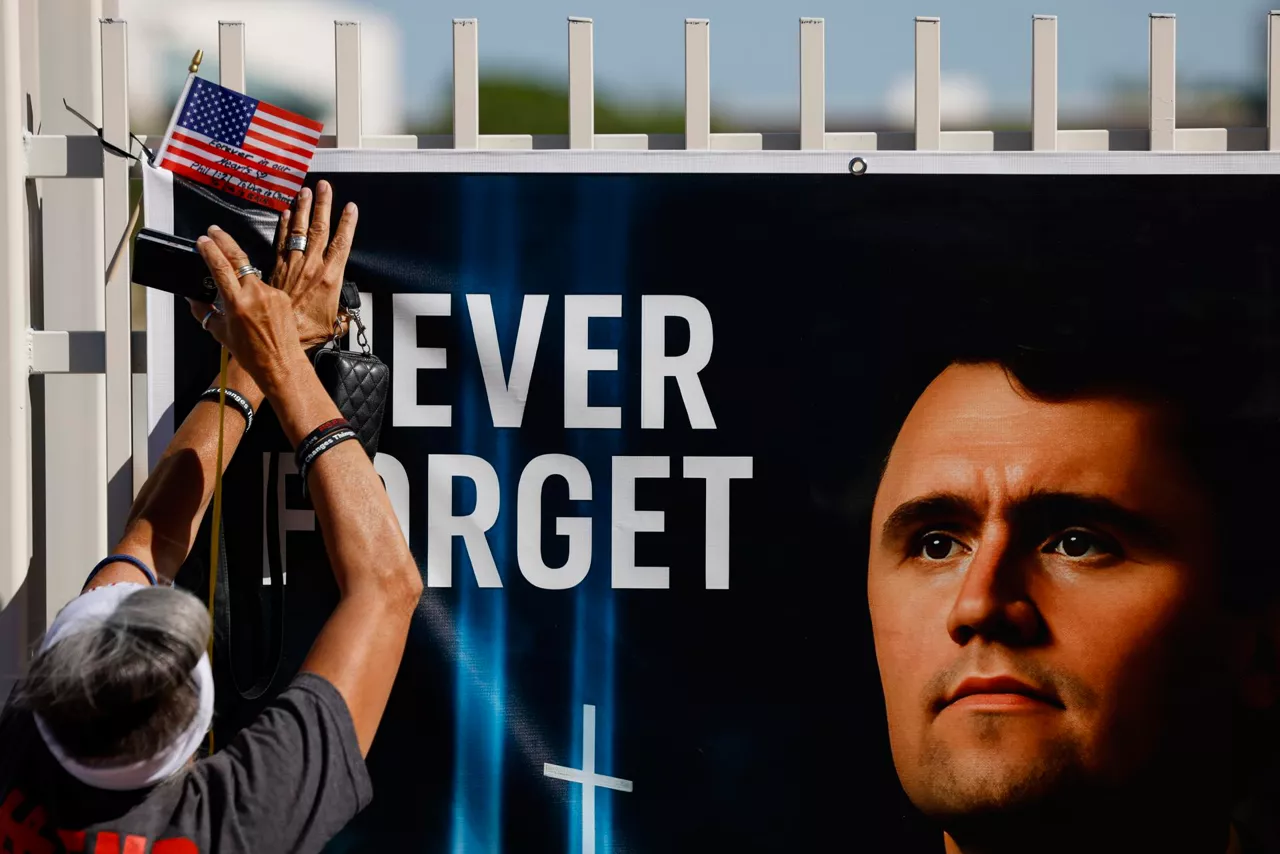 PHOENIX (United States), 20/09/2025.- A person places an American flag at a makeshift memorial for conservative political activist Charlie Kirk outside the Turning Point USA headquarters in Phoenix, Arizona, USA, 20 September 2025. A memorial service for Kirk is scheduled to take place on 21 September in Glendale, Arizona. (Fénix) EFE/EPA/CAROLINE BREHMAN
