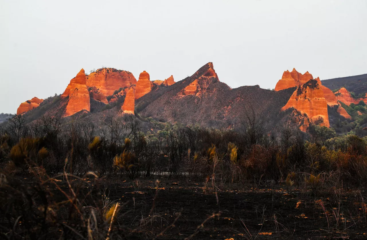 LAS MÉDULAS, 12/08/2025.- Paraje quemado en el espacio natural de Las Médulas en la provincia de León este martes. La mejor evolución del incendio forestal declarado en Yeres (León) y que ha afectado a Las Médulas, catalogado por la Unesco como Patrimonio de la Humanidad, ha permitido que los vecinos de cuatro de las cinco localidades desalojadas hayan podido regresar a sus casas, alrededor de 600 personas. EFE/Ana F. Barredo
