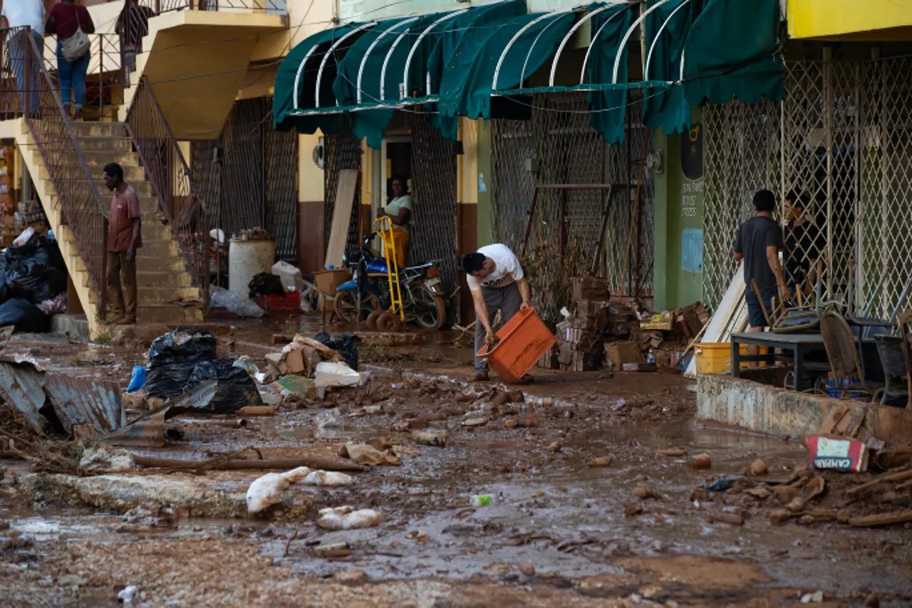 AME3831. SANTA CRUZ (JAMAICA), 30/10/2025.- Personas limpian en lodo en pertenencias afectadas por el paso del huracán Melissa este jueves, en Santa Cruz (Jamaica). Más del 70 % de los clientes siguen sin servicio eléctrico en Jamaica y 134 carreteras están bloqueadas, debido a la destrucción causada por el huracán Melissa, que impactó la isla como categoría 5. EFE/ Orlando Barría
